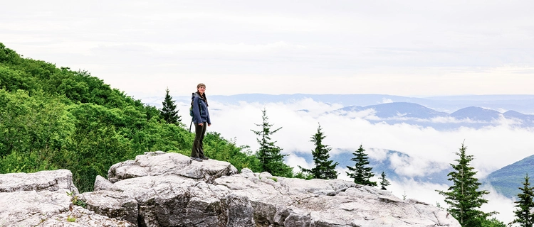 A person standing on top of a mountain overlooking the view